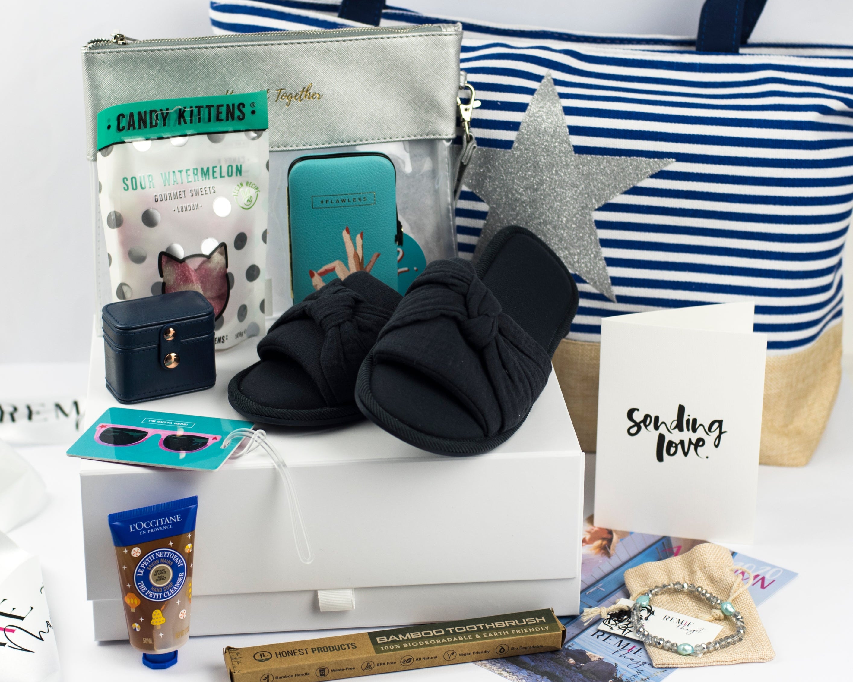 Assorted items, including a striped bag, slippers, and other Autumn Sun items, on a white surface