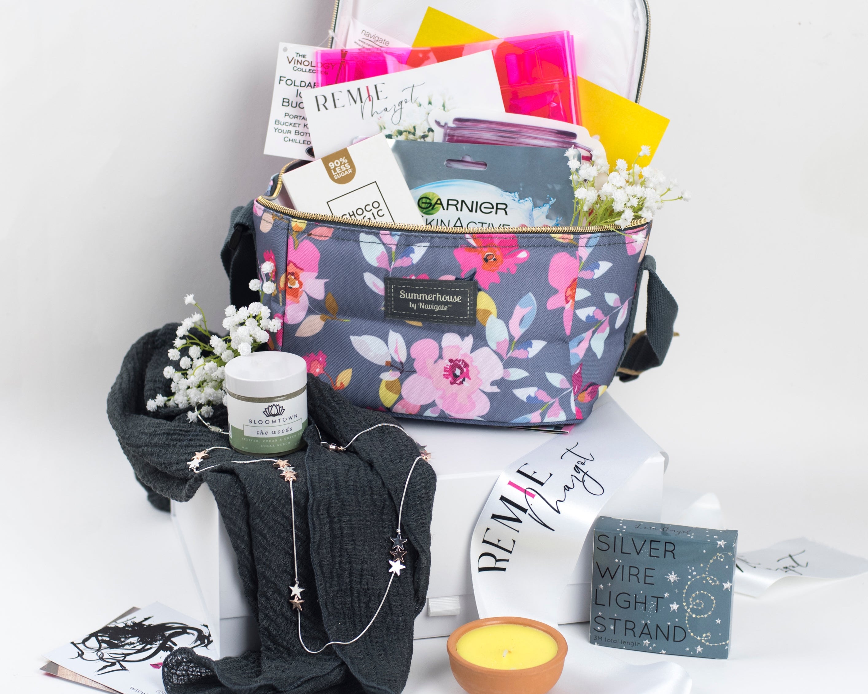 Floral-patterned cool bag with beauty products and accessories on a white background